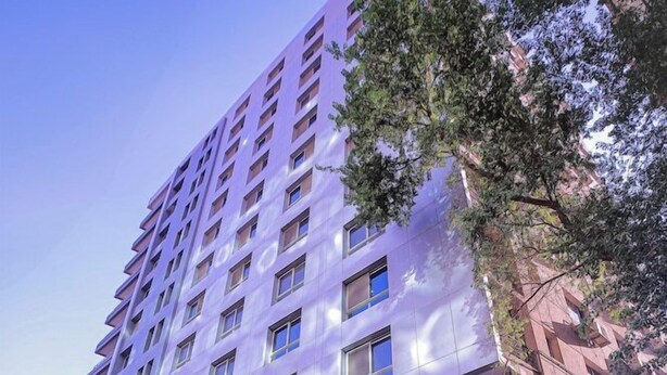 A multi-story hotel with a prominent entrance featuring a traditional archway and a restaurant sign. - Cairo Taj Dokki Families Tower Hotel (Giza)