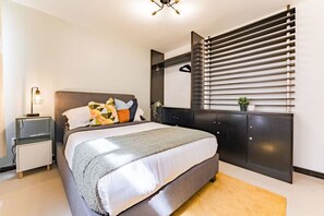 A modern bedroom with a bed, bedside tables, a wardrobe, and a window with blinds. - Artful Roma Norte Stay Near Museums & Cafés (Cuauhtemoc)