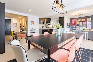 A modern kitchen with a central island, a dining area with a large table and chairs, and a living area with a sofa and artwork on the wall. - Artful Roma Norte Stay Near Museums & Cafés (Cuauhtemoc)