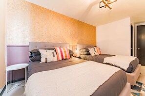 A hotel room with two beds, a brick wall, and a modern light fixture. - Artful Roma Norte Stay Near Museums & Cafés (Cuauhtemoc)
