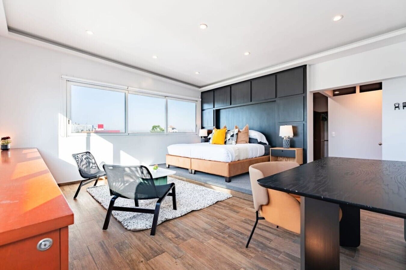 Une chambre à coucher moderne, avec un lit, des tables de chevet et une grande fenêtre.