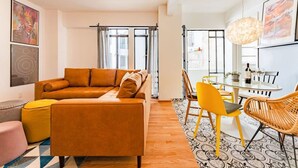 A modern living room with a sofa, a dining table with chairs, and a large window with curtains. - Vibrant Condo in Roma Norte Walk to Museums & Eats (Mexico City)