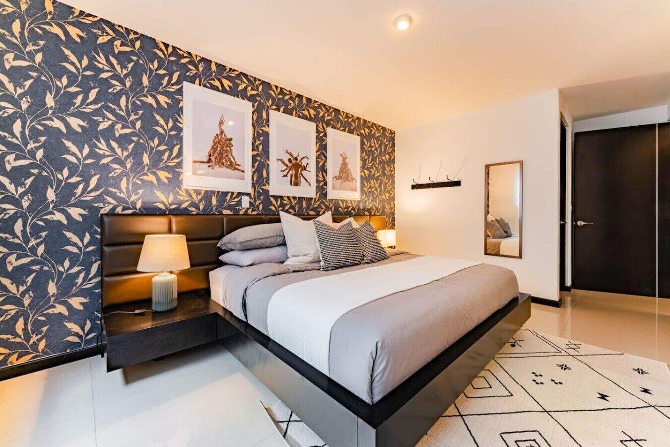 A modern bedroom with a bed, bedside tables, and wall art.