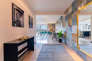Un intérieur moderne comprenant un coin repas, une cuisine et un couloir menant à l’espace de vie.
