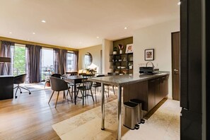 A modern kitchen with a central island, dining area with chairs, and a view of the outdoors. - Spacious Roma Norte Stay: Balcony & Workspace (Mexico City)