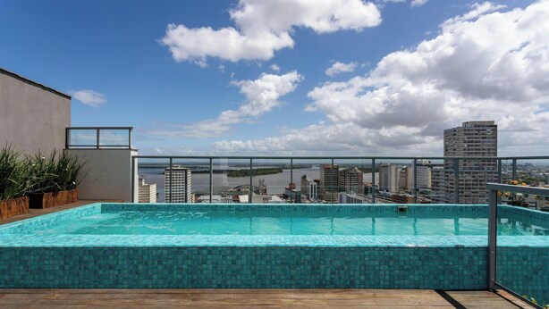 A rooftop swimming pool with a city view, surrounded by buildings and a clear sky. - Studio in Historic Center Near Santa Casa Tco0712 (Porto Alegre)