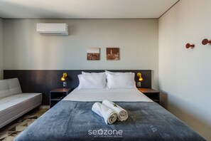 A hotel room with a bed, a sofa, two wall-mounted lamps, and two framed pictures. - Studio in Centro Hist. Next Merc. Public Tco0815 (Porto Alegre)