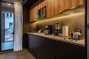 Eine moderne Küche mit integriertem Mikrowellenherd, einer Kaffeemaschine und einem Wasserkocher.