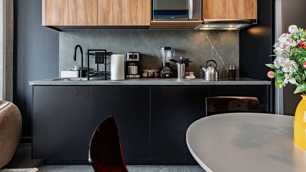 A modern kitchen with wooden cabinets, a microwave, a coffee maker, and a kettle. - Stay Together: 3 Apts, Rooftop & Gym Near Reforma (Mexico City)