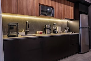 A modern kitchen with a built-in microwave, coffee maker, and blender on the counter. - Stay Together: 3 Apts, Rooftop & Gym Near Reforma (Mexico City)