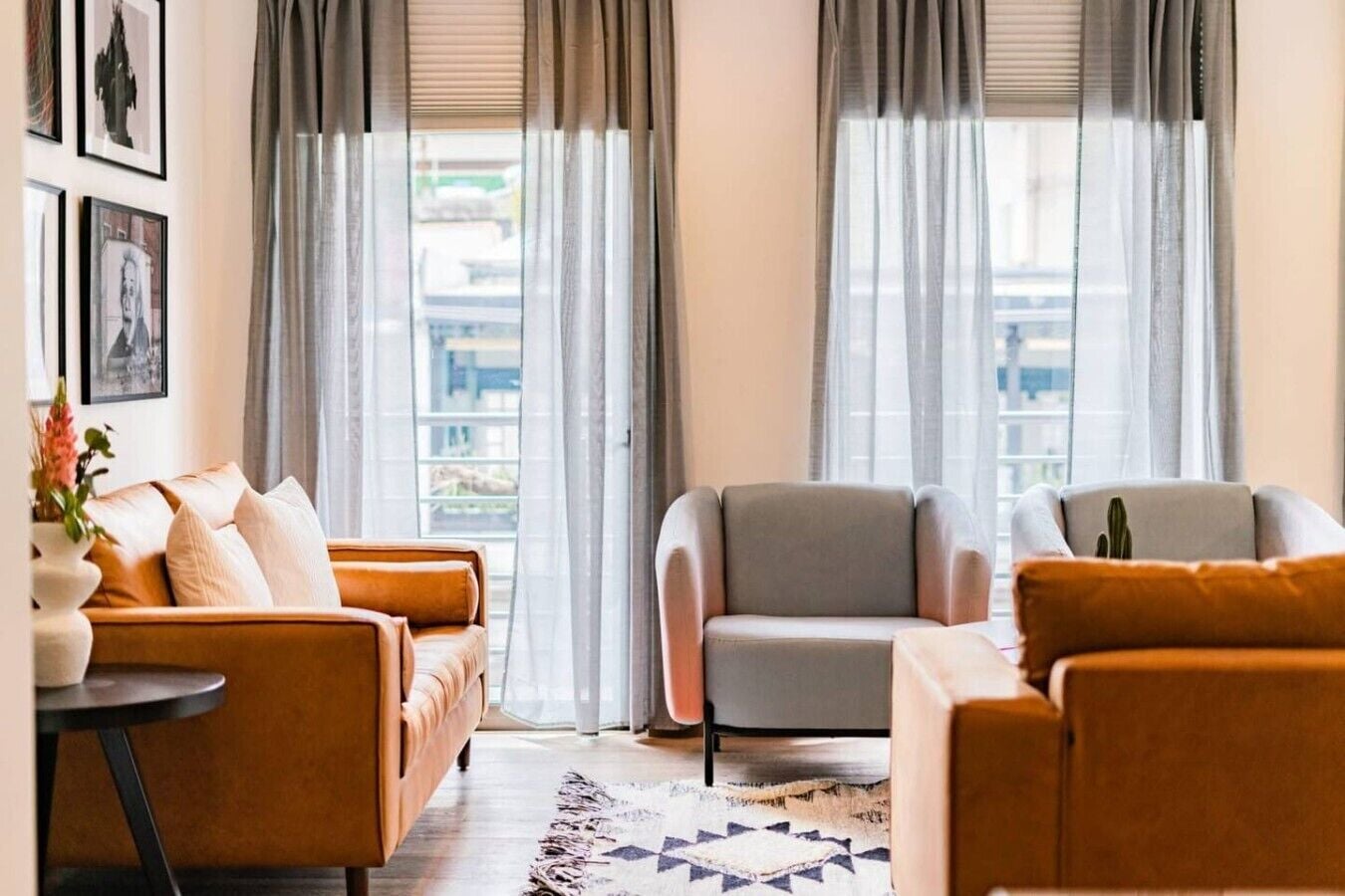 Ein modernes Wohnzimmer mit einer Couch, Sesseln und einem Couchtisch.