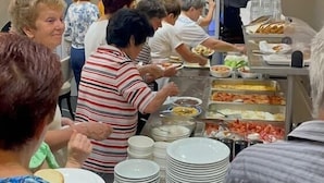 A buffet setup with multiple food stations and guests serving themselves. - Hotel Lubjana (Durrës)