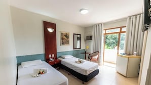 A hotel room with two beds, a desk, a chair, a TV, and a window with curtains. - Hotel Alvorada Taguatinga (Taguatinga)