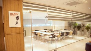 A conference room with a glass partition, wooden paneling, and a 'Happy Holiday' sign.