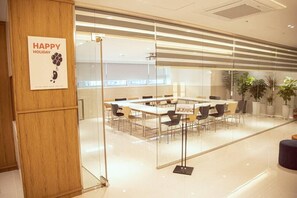 A conference room with a glass partition, wooden paneling, and a 'Happy Holiday' sign.