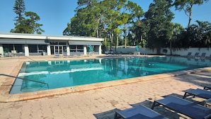 A swimming pool with lounge chairs and a building in the background. - Spacious 1 bedroom apartment in awesome Sarasota with swim pool and fitness room (Sarasota)