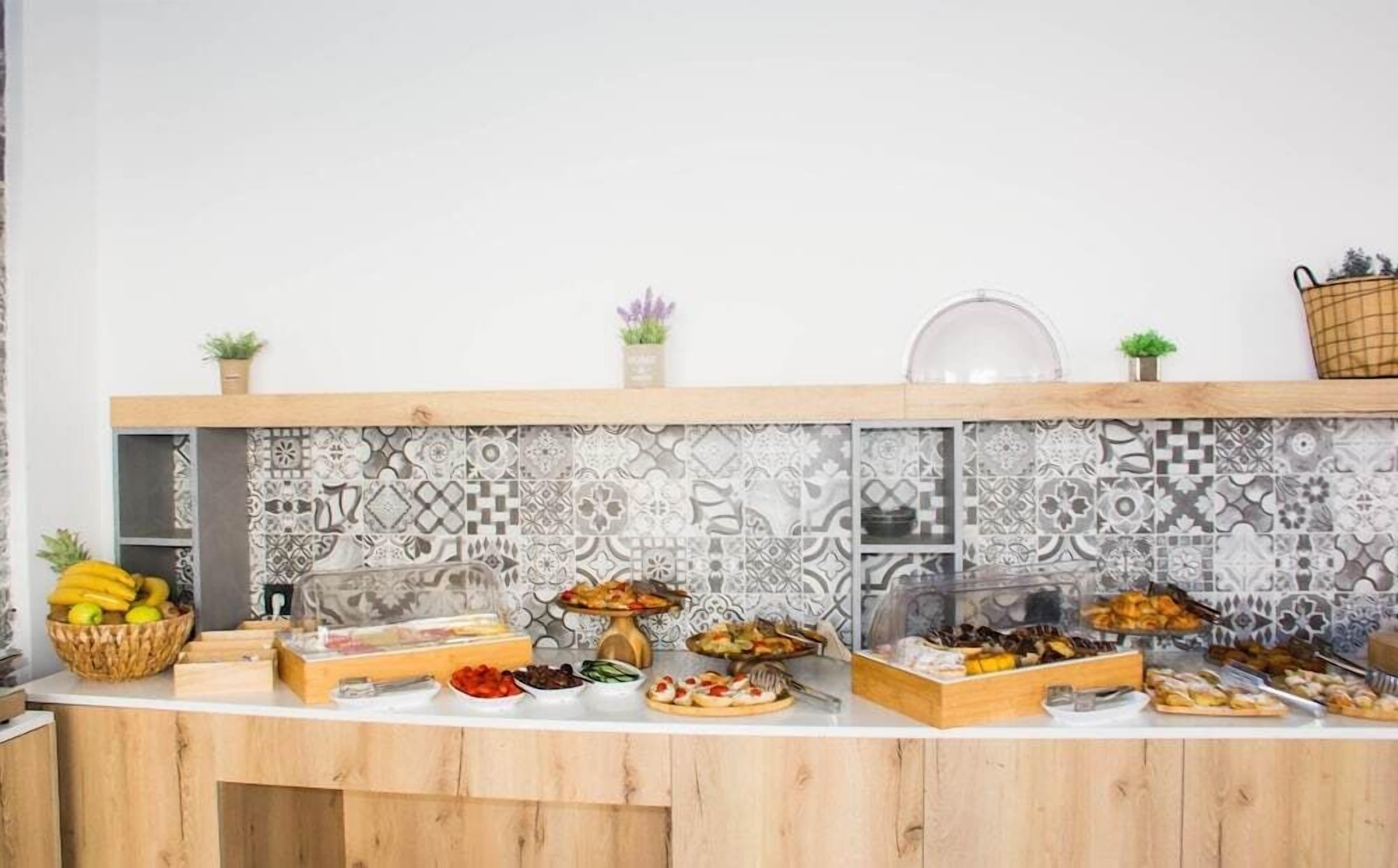 A buffet setup with various food items and decorative elements on a wooden counter.