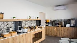 A modern kitchen with a wooden counter, tiled backsplash, and various kitchen appliances.