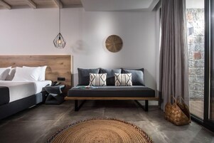 Un dormitorio moderno con cama, sofá, un reloj de pared y una ventana con cortinas.