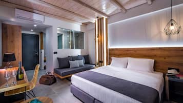 Un dormitorio moderno con una cama grande, mesitas de noche, una zona de estar y techo de madera.