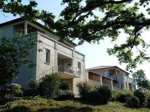 A two-story residential building with a balcony on the upper floor. - Olydea Le Chateau De Jouarres (Azille)