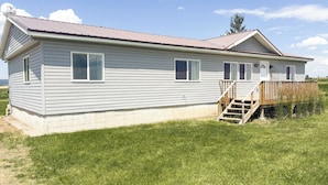 A single-story house with a front deck and a small staircase leading to a door. - Teton View Farm Stay—Newly remodeled whole home! 3 spacious bedrooms, 2 baths (Unknown)