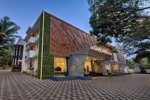 A modern building with a geometric facade, a visible entrance, and a name sign. - De Garland, Palolem - AM Hotel Kollection (Canacona)