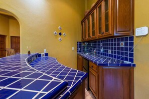A kitchen with blue-tiled countertops, wooden cabinets, and a wall-mounted electrical outlet. - Ocean views, close to beach and marina boardwalk! (San Carlos Nuevo Guaymas)
