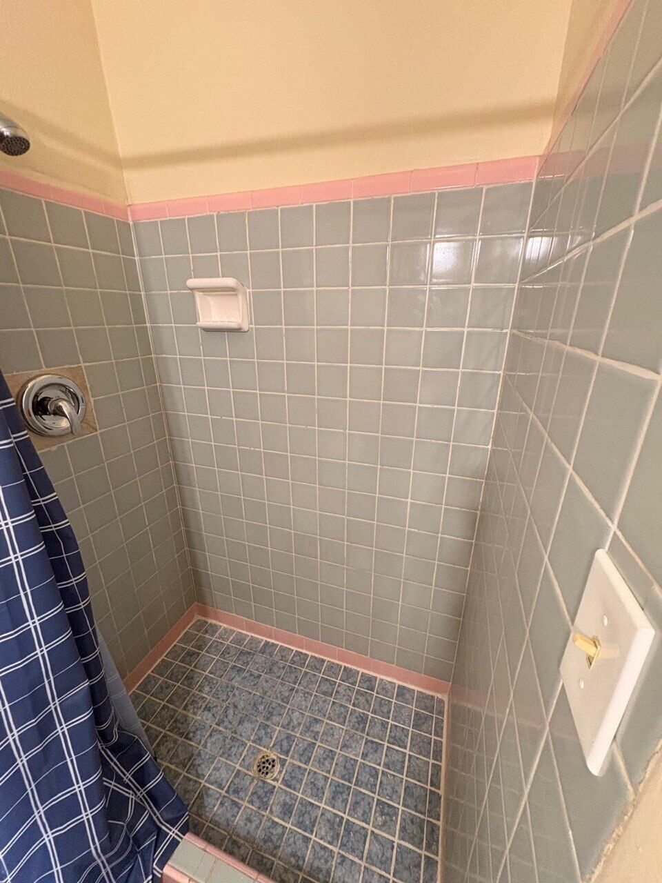 Une petite salle de bain comprenant un espace douche, des toilettes et un porte-serviettes.