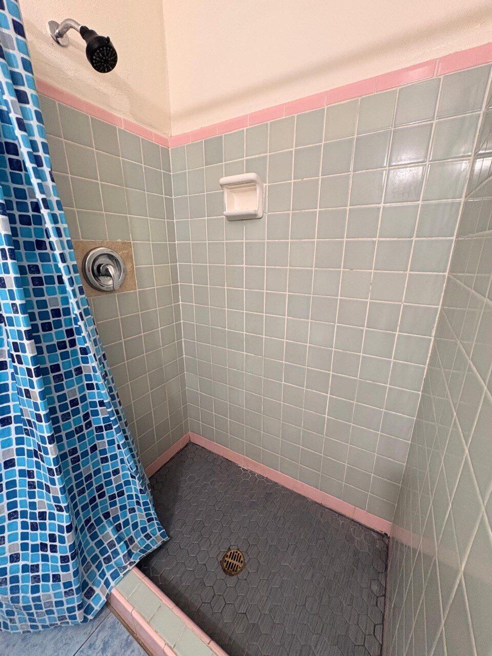 Ein Badezimmer mit Duschbereich, gefliesten Wänden und einer Duschvorhang.
