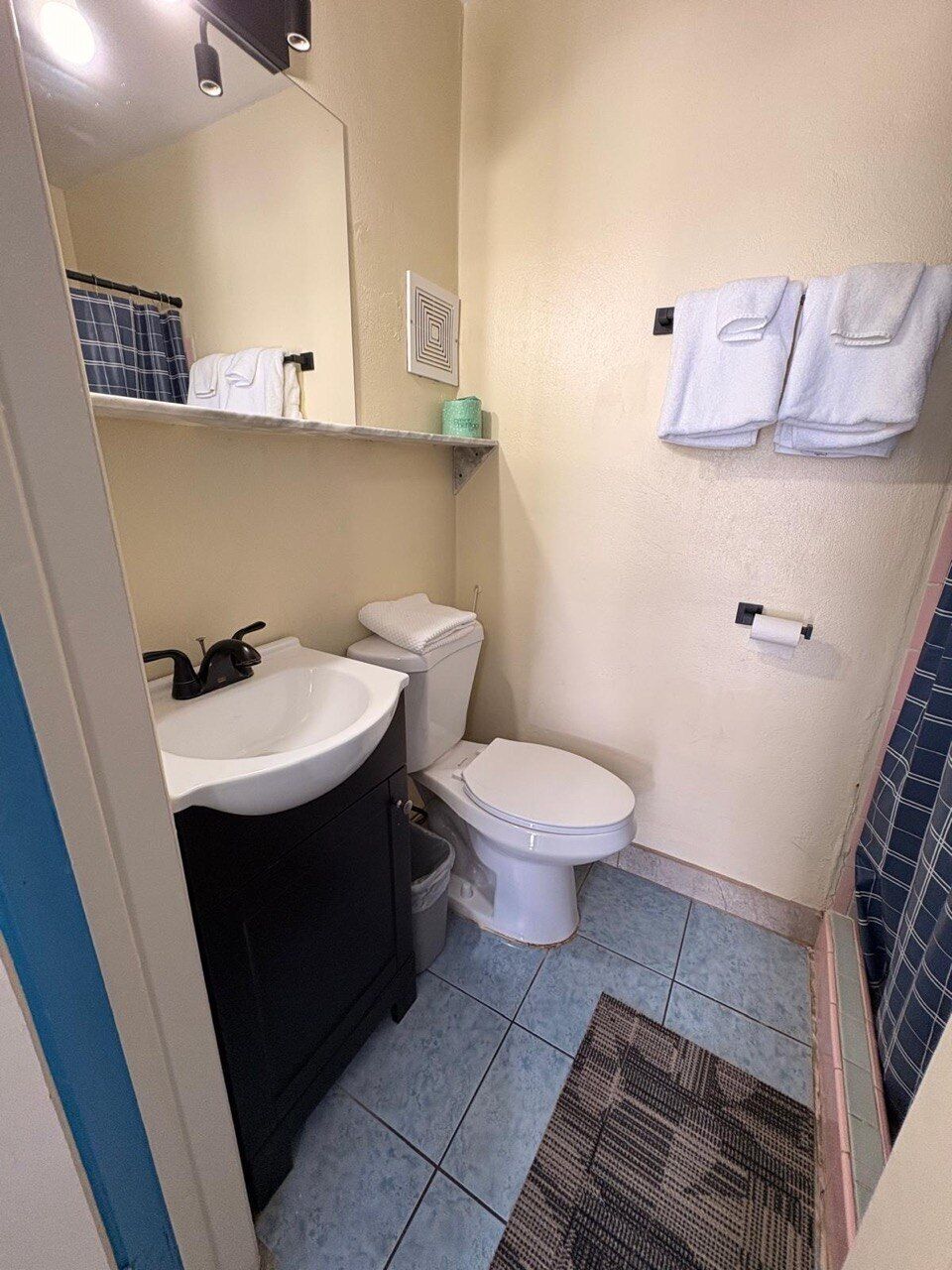 A bathroom with a sink, toilet, and towel rack.