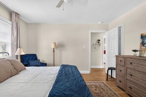Une chambre à coucher comprenant un lit, un bureau, une chaise, une lampe et une armoire.