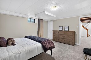 Ein Schlafzimmer mit Bett, Kommode und Treppe.