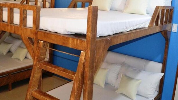 A bunk bed room with a blue wall and wooden headboard. - Casa Del Camba Hotel and Restaurant by Zuzu (Alaminos)