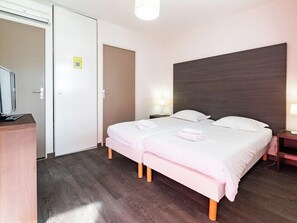 A hotel room with a bed, bedside tables, a desk, and a television. - Residence Vacanceole Les Chambres de la Baie (Roz-sur-Couesnon)