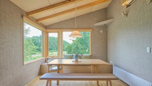 Et værelse med en træbænk, et bord og en hængende lampe.