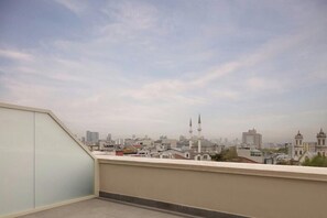 Vista da cidade a partir de uma varanda, com céu claro.
