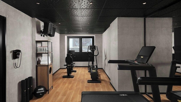 A gym with exercise equipment, a treadmill, and a wall-mounted television. - Moxy Istanbul Beyoglu (Istanbul)