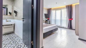 A modern hotel room with a bathroom, a bed, and a desk. - Hotel Intercity Istanbul Airport (Arnavutköy)