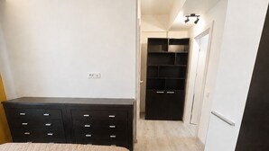Un dormitorio con cama, cómoda, armario y armario ropero.