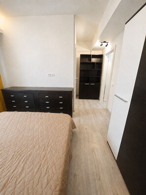 Ein Schlafzimmer mit einem Bett, einem Schminktisch, einem Kleiderschrank und einem Schrank.