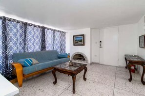 A living room with a sofa, a coffee table, a fireplace, and a door. - Mediterranean Scape (San arlos Nuevo Guaymas)