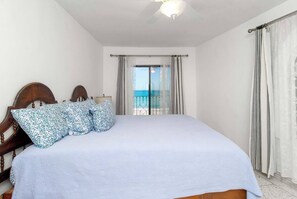 A bedroom with a bed, a view of the sea through a window, and a balcony with curtains. - Mediterranean Scape (San arlos Nuevo Guaymas)