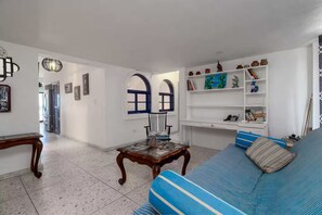 A living room with a blue sofa, a coffee table, and a bookshelf. - Mediterranean Scape (San arlos Nuevo Guaymas)