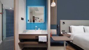 A modern hotel room with a bathroom, a bed, a bedside table, and a nightstand. - Holiday Inn Express Xi'an Qujiang Center (Xi'an)