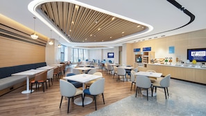 A modern hotel lobby with a central seating area, a reception desk, and a large screen displaying the hotel name. - Holiday Inn Express Xi'an Qujiang Center (Xi'an)