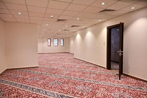 A hotel corridor with patterned carpet, a door, and a view of the hallway. - Cent Al Khair Hotel Makkah (Makkah)