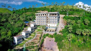 A multi-story hotel with a pool and lush greenery surrounding it. - Flamingo Waecicu Labuan Bajo (Labuan Bajo)