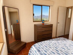 A bedroom with a bed, a dresser, a mirror, and a window with a view of mountains. - OMG Ocean Views! | Walk to beach! | Modern kitchen (San Carlos Nuevo Guaymas)