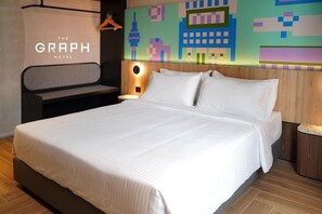 Une chambre d’hôtel avec un grand lit, une tête de lit dotée d’une lampe intégrée et une fresque murale aux couleurs vives.